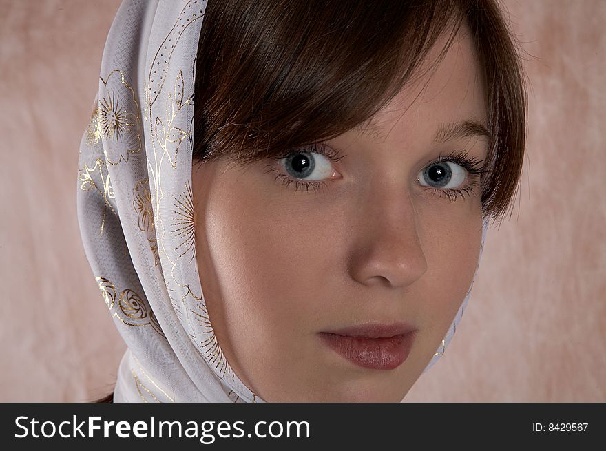Portrait of the girl in a kerchief in an interior