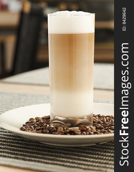 Latte on the tall glass on the table