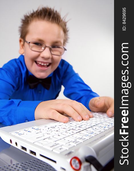 Funny school boy with laptop isolated over white