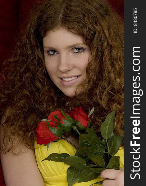 Red haired teenager with red roses, attractive youthful with long hair