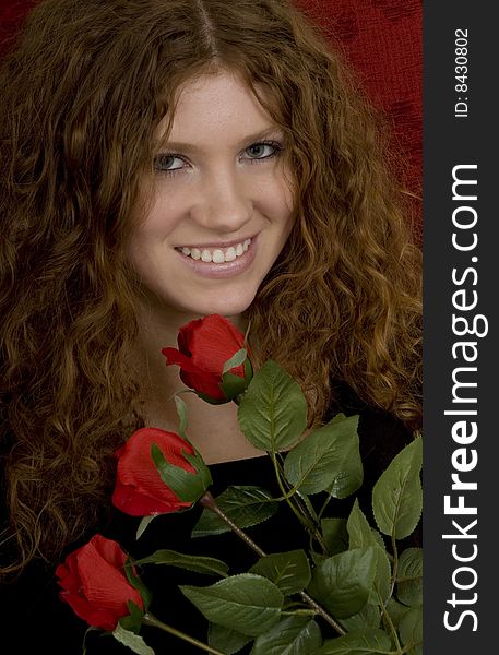 Red haired teenager with red roses, attractive youthful with long hair