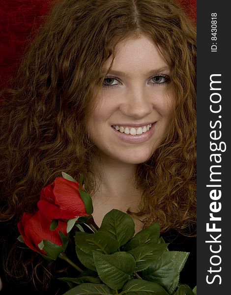 Red haired teenager with red roses, attractive youthful with long hair