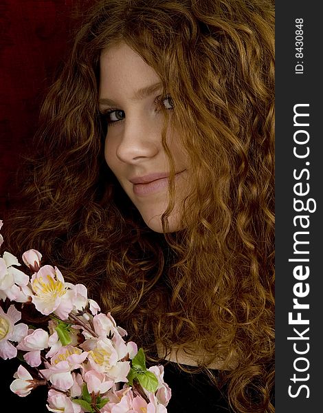 Red haired teenager with red roses, attractive youthful with long hair