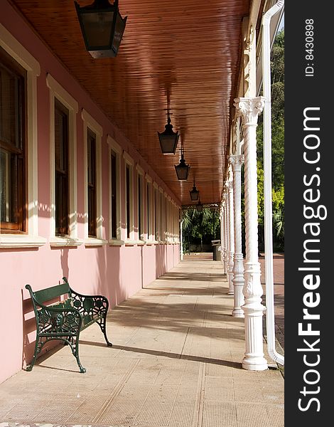 Angled view of the porch of a pink building in an old mining village in_ South Africa