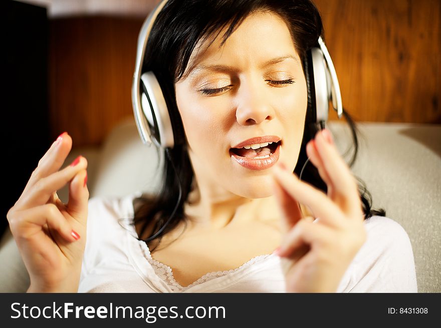 Beautiful woman listening music in headphones. Beautiful woman listening music in headphones