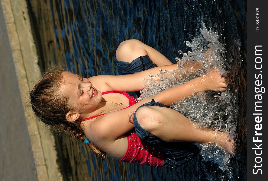 Girl playing in water fountain