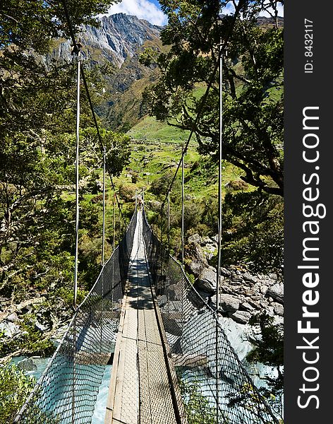 Swing bridge across a mountain river in New Zealand