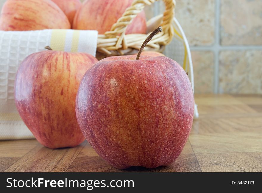 Focus on front apple with apples and basket behind