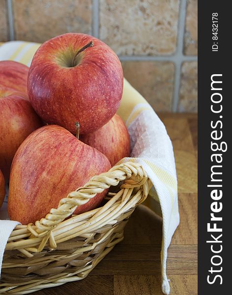 Wicker basket lined with linen holding several apples