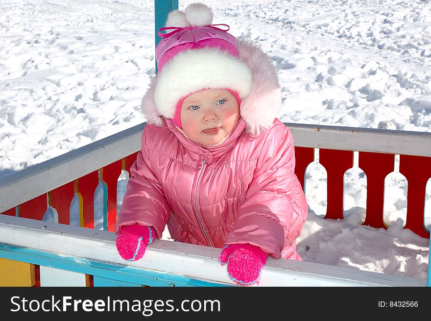 Pretty little girl and winter playground.