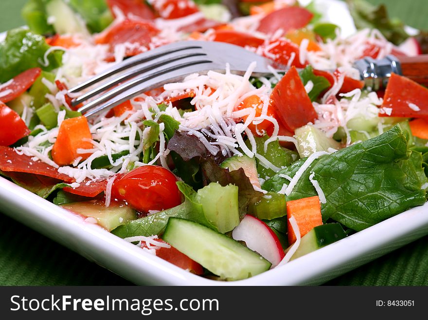 Close up of a delicious fresh garden salad with a fork. Close up of a delicious fresh garden salad with a fork