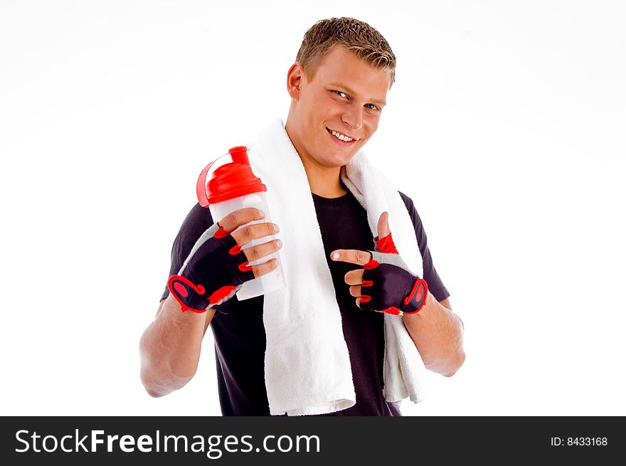 Smiling muscular man pointing at water bottle with white background