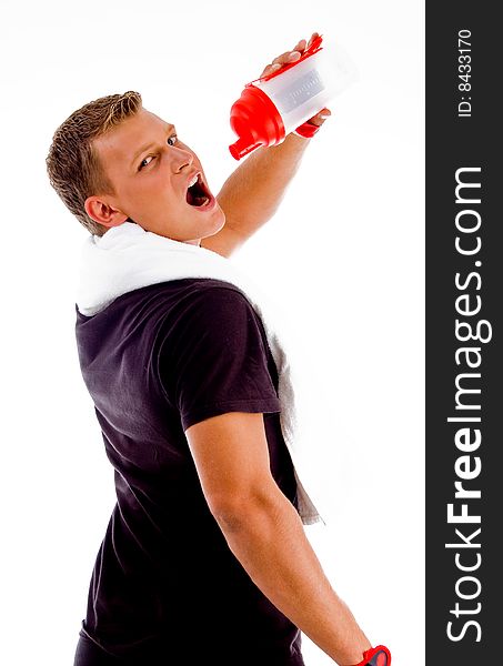 Back pose of muscular man drinking from water bottle on an isolated background