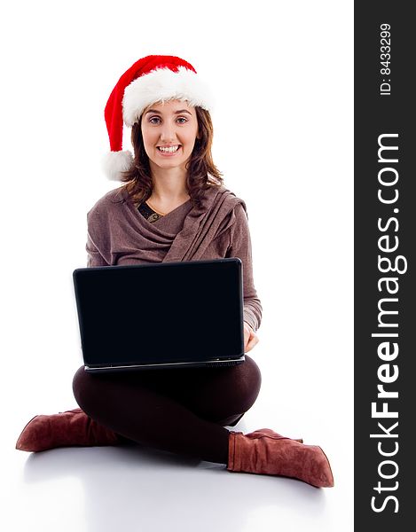 Cheerful young woman in christmas hat posing with laptop on an isolated white background