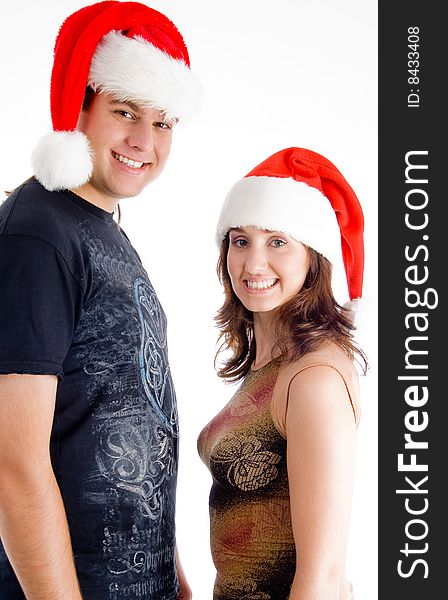 Couple with christmas hat and looking at camera on an isolated background