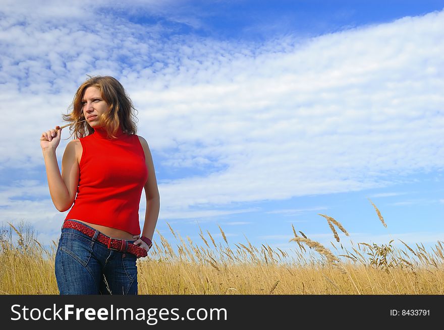 The girl in an autumn field against the sky. The girl in an autumn field against the sky