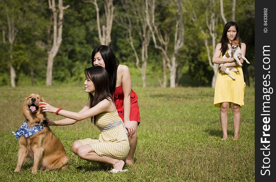 Girlfriends Outdoor In The Park With Pet Dogs