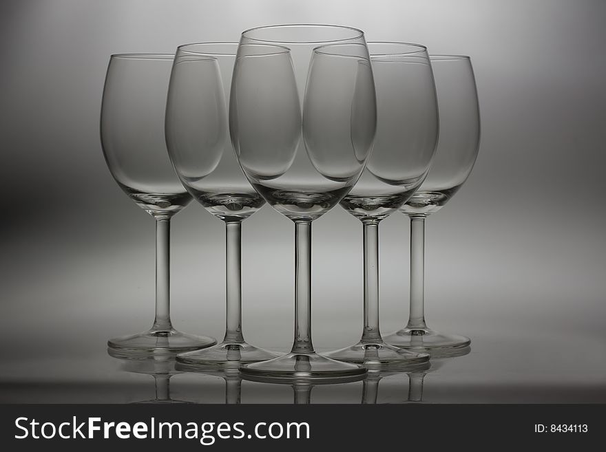 Five wine glasses on grey background