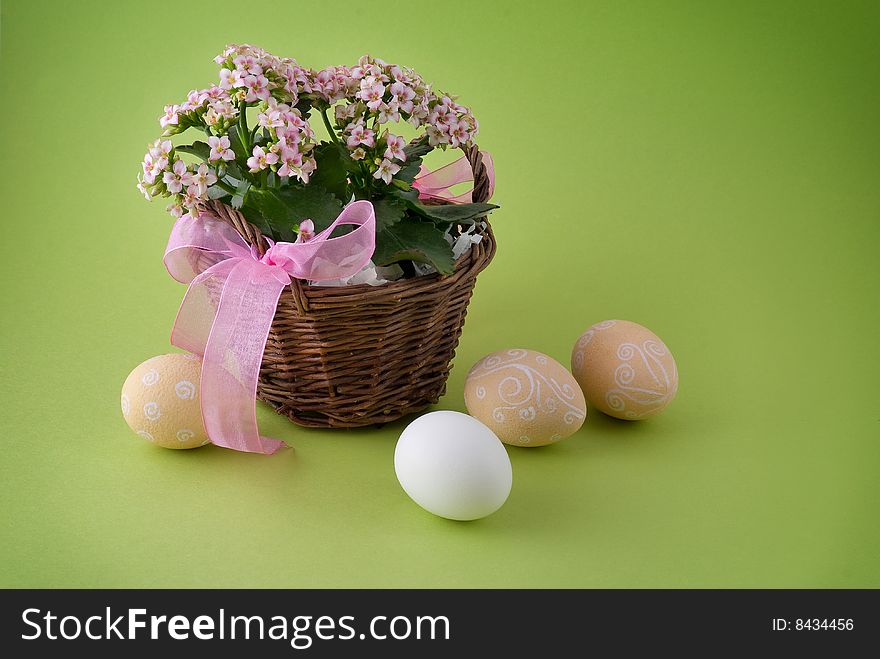 Easter eggs and basket with flower and pink ribbon