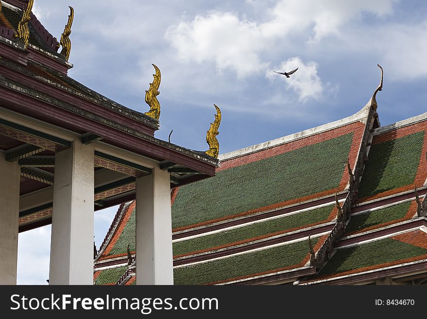 Roofs of buddhist temple with eagle flying in the background, bangkok, thailand. Roofs of buddhist temple with eagle flying in the background, bangkok, thailand.