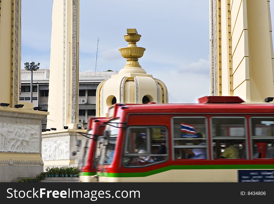 Two buses passing by the democracy monument in bangkok, thailand. Two buses passing by the democracy monument in bangkok, thailand.