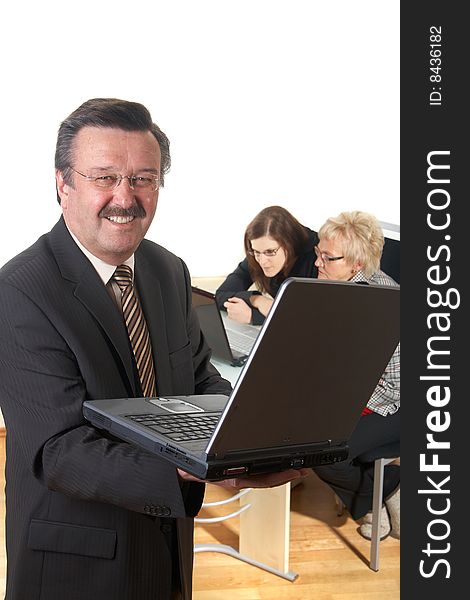 Businessman in office environment with laptop. Three people with focus on mature boss in front. Isolated over white. Businessman in office environment with laptop. Three people with focus on mature boss in front. Isolated over white.