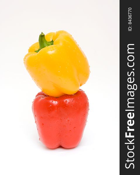 Red and yellow peppers with water drops isolated