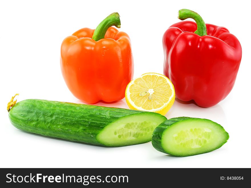 Fresh vegetables fruits (paprika, cucumber and lemon) isolated on a white background. Shot in a studio. Fresh vegetables fruits (paprika, cucumber and lemon) isolated on a white background. Shot in a studio.