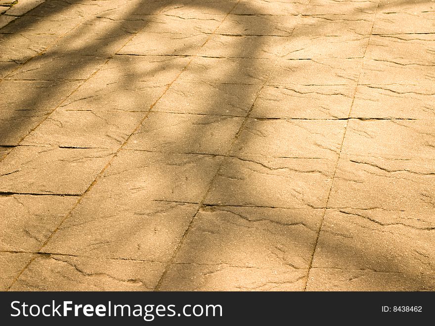 Dappled light on stone texture of path or sidewalk suitable for spring or summer background