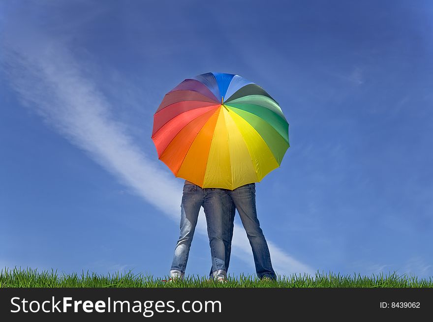 Two Pairs Of Jeans Under Colorful Umbrella