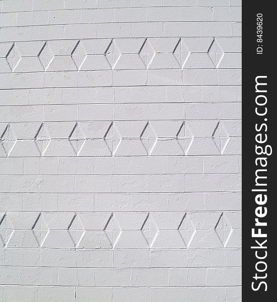 White painted brick or block exterior wall with diamond texture. White painted brick or block exterior wall with diamond texture.