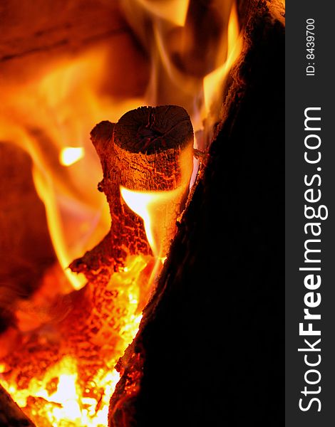 Close view of a wood log being burned in red hot flames. Close view of a wood log being burned in red hot flames.