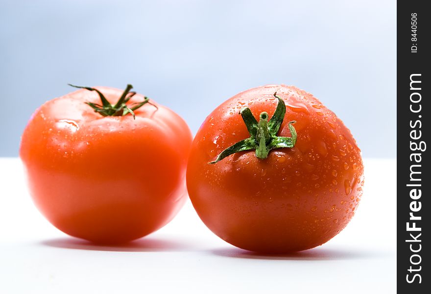 Two tomatoes with drops on white. Two tomatoes with drops on white
