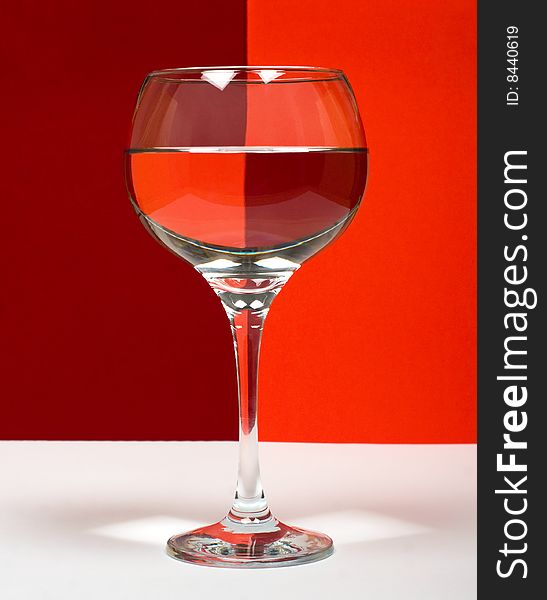 One wineglass in  red color background