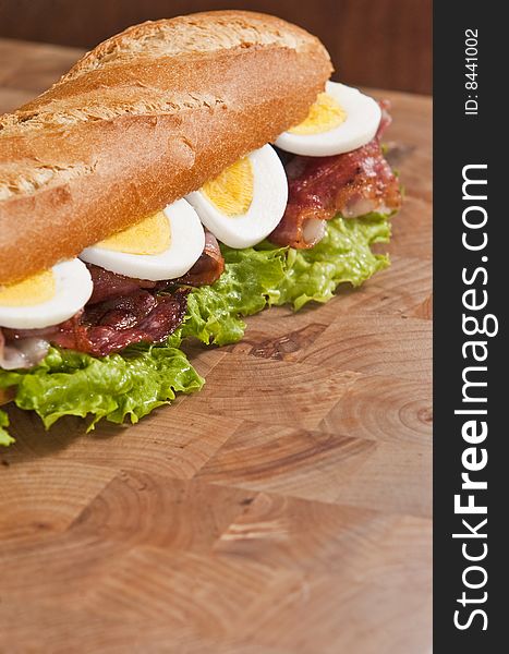 Bacon and egg sandwich on wooden board