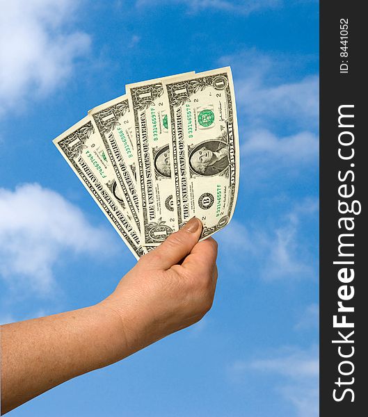 Hand with dollars on sky background