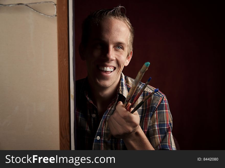 Handsome young artist with brushes