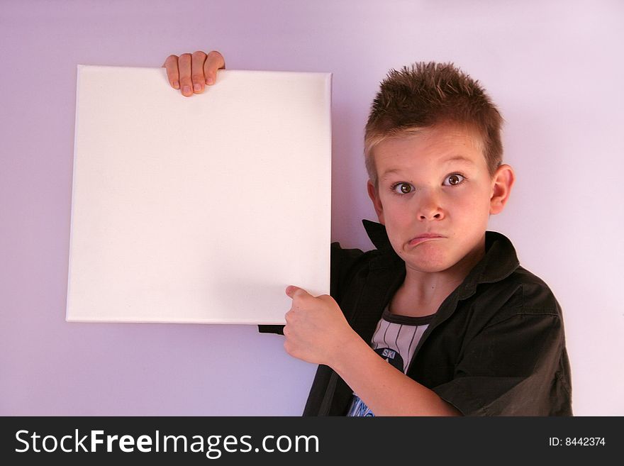 A boy is holding a frame in his hands. A boy is holding a frame in his hands