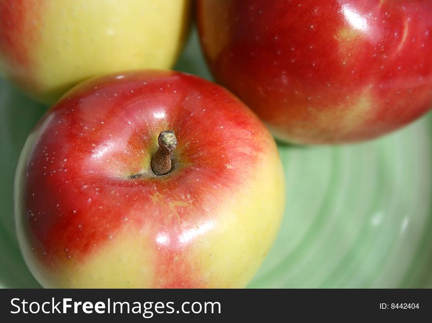 Fresh apples on the green plate