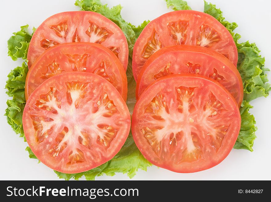 Four Slices of Tomato Lying on Greens. Four Slices of Tomato Lying on Greens