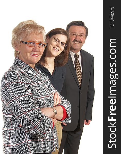 Small group of business people in business suits standing looking forward. Focus is on the mature woman in front. Small group of business people in business suits standing looking forward. Focus is on the mature woman in front.