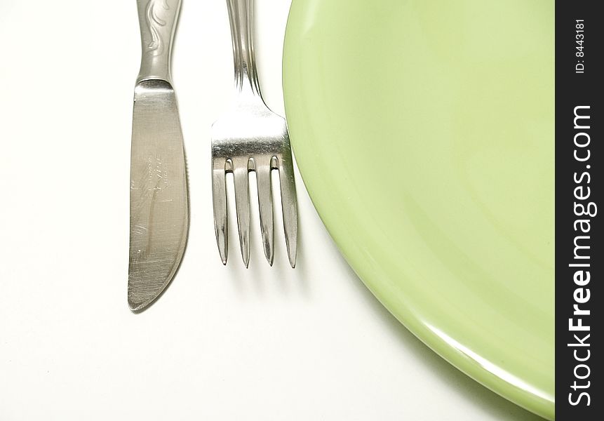 Plate and cutlery photograph in the foreground on a white background