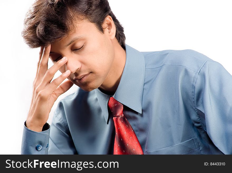 Tired young businessman with eyes closed and head resting on hand, white background.