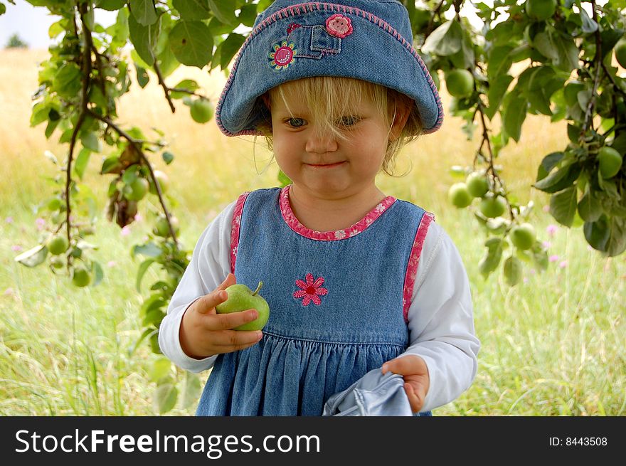 Proud young girl having just picked her first apple ever. Proud young girl having just picked her first apple ever.