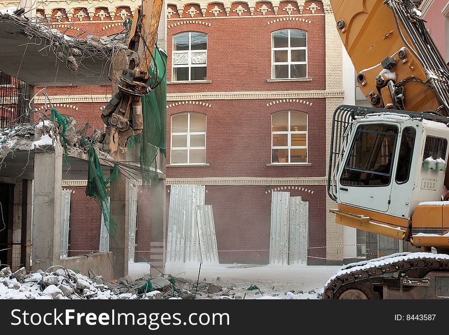 Heavy dredger is demolishing a house. Heavy dredger is demolishing a house