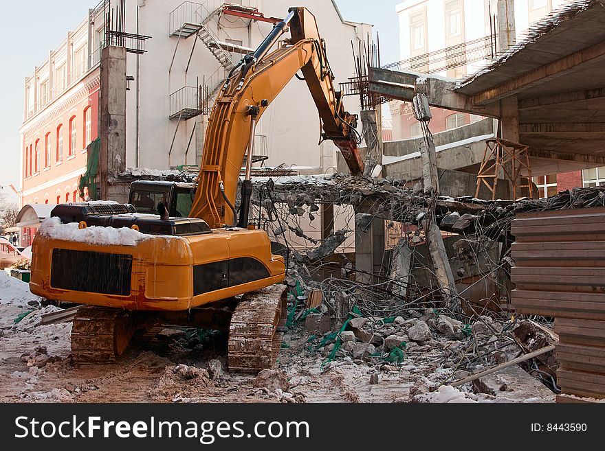 Heavy dredger is demolishing a house. Heavy dredger is demolishing a house