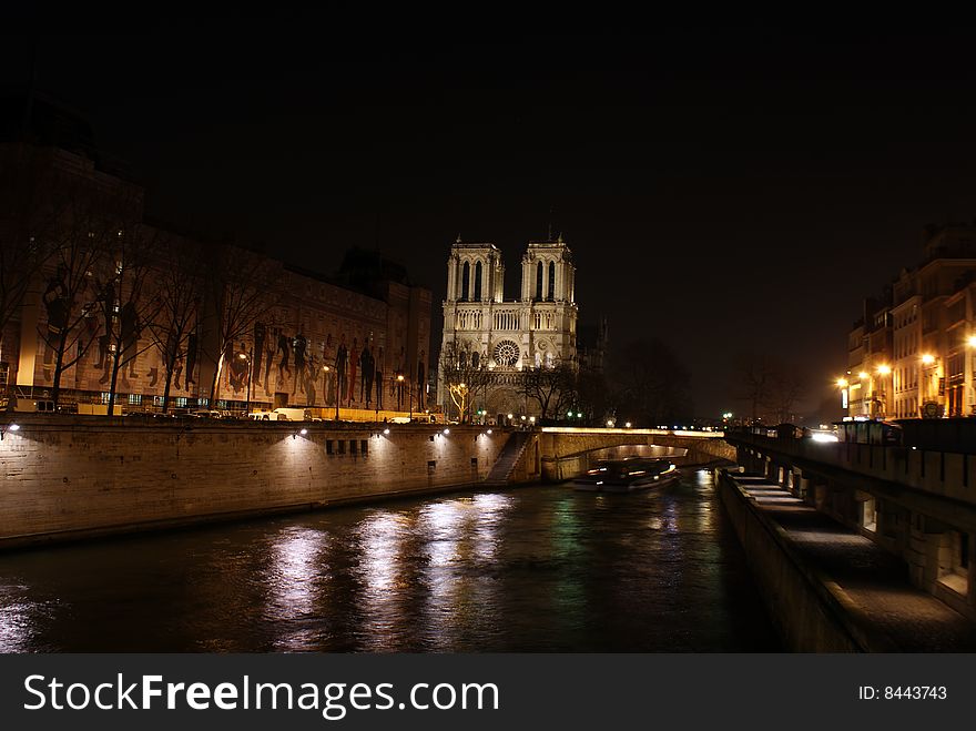 Siene river in paris at night with notre dame church in the background