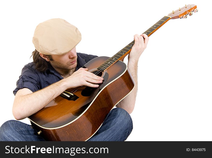 Guitarist with hat playing an acoustic guitar seated. Guitarist with hat playing an acoustic guitar seated