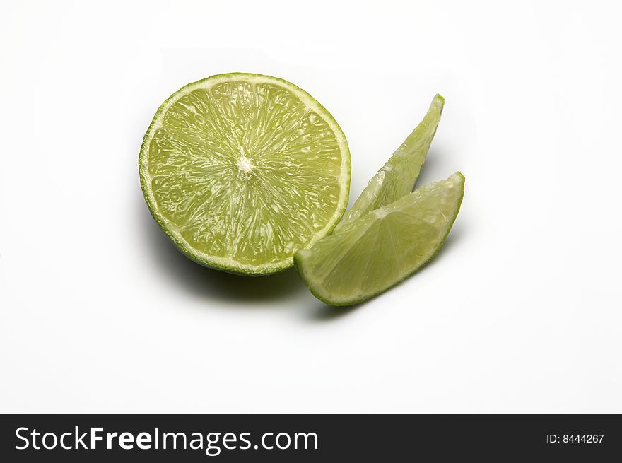 Lime cut in half with two wedges isolated on white