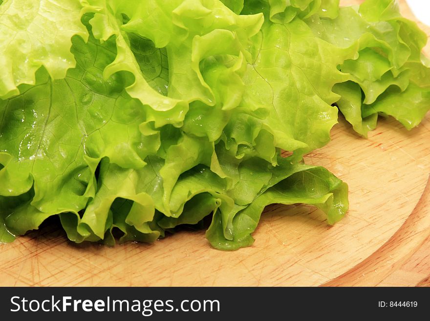 green salad on a wooden plate isolated on a white